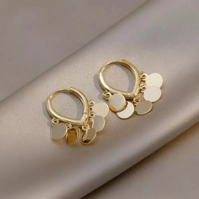 Eleganta örhängen med gyllene tofsar